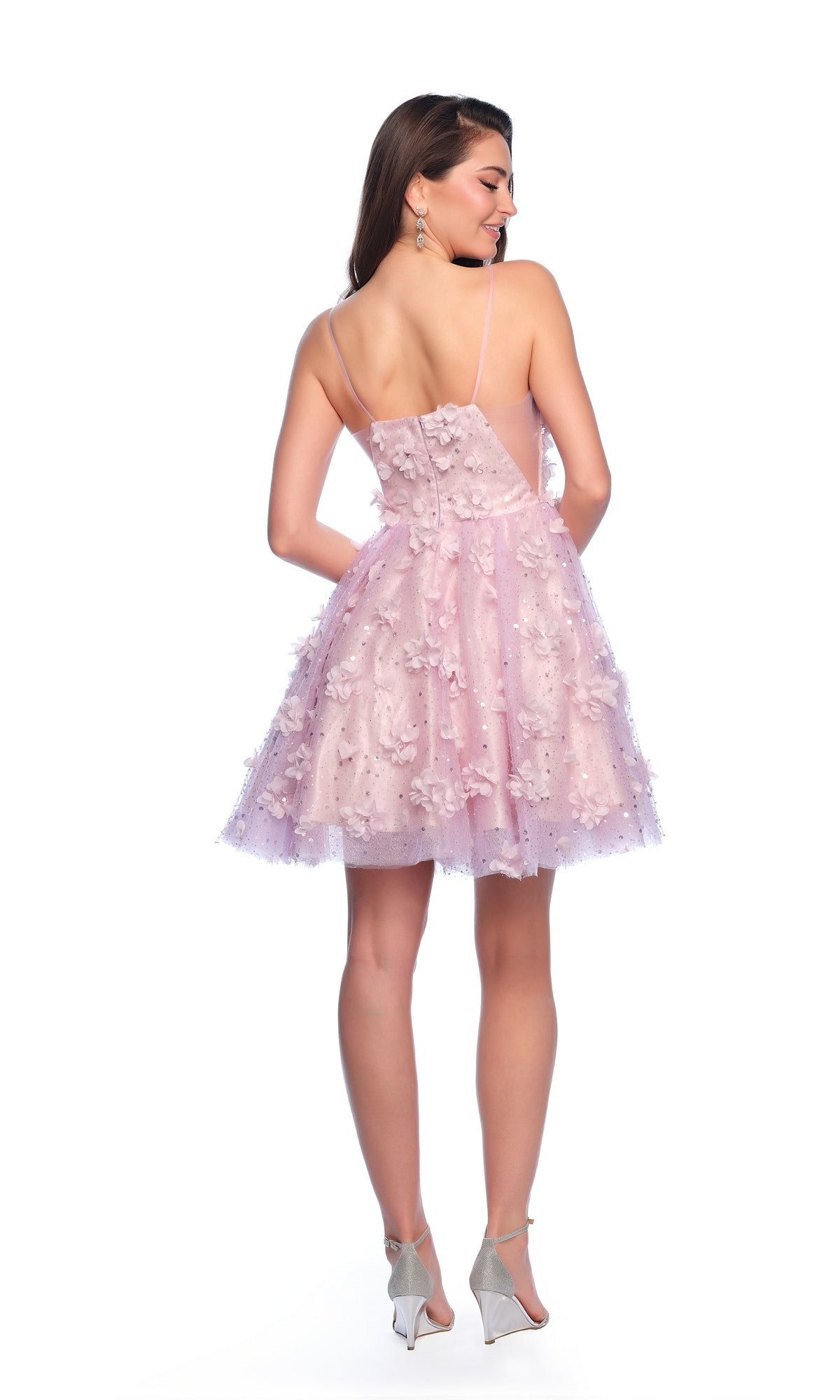 A woman faces away in the Dave and Johnny Short Purple Hoco Dress 11751, a sleeveless, backless designer dress with floral details and high heels, set against a white background.